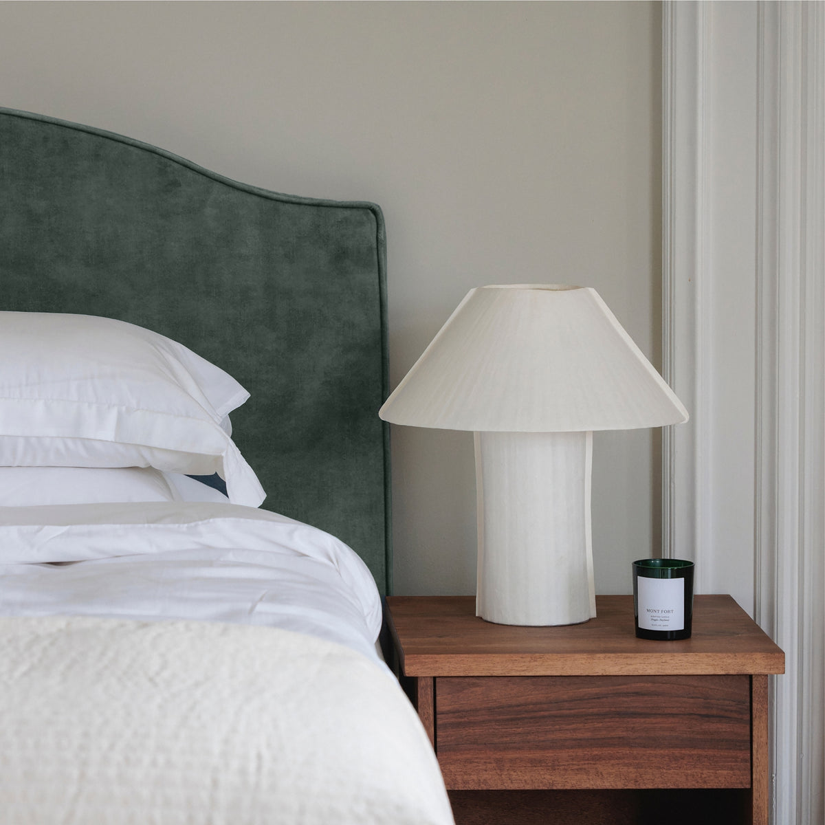 The Headboard in Tuscan Forest velvet, close to the bedside table and lamp